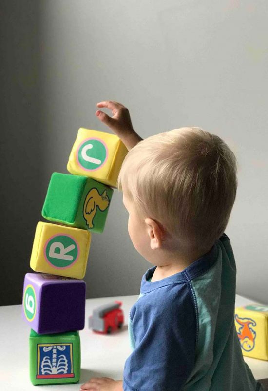 Start a daycare at home. Boy playing with blocks